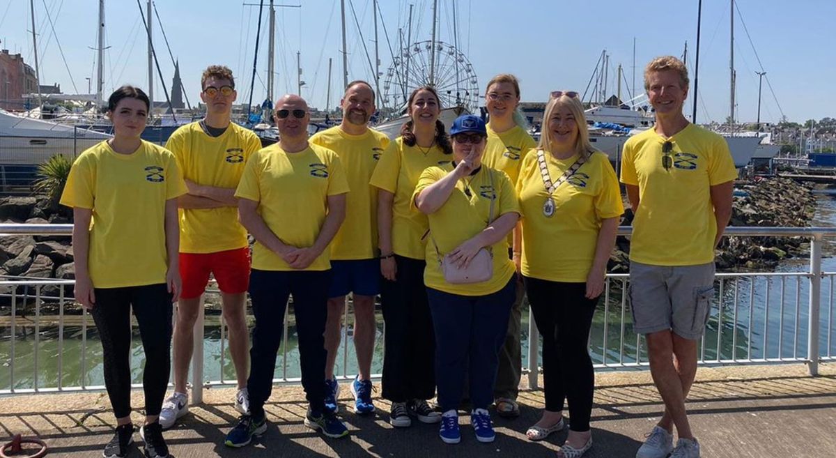 SERC students and staff who participated in the rowing team with the Mayor of Ards and North Down Borough Council standing on pier.